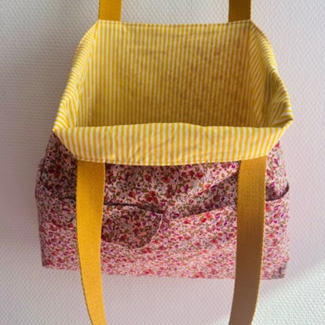 Intérieur du tote bag fleuri révélant une doublure à rayures jaunes et blanches