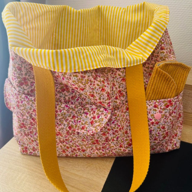 Intérieur du sac rayé jaune avec bouton pression pour fermer le tote bag en sécurité