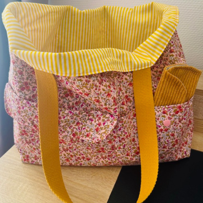 Intérieur du sac rayé jaune avec bouton pression pour fermer le tote bag en sécurité